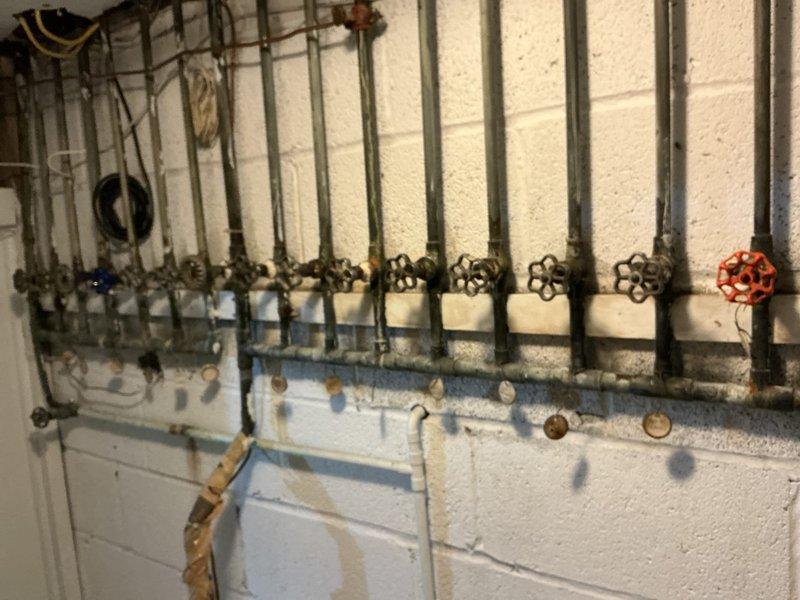 Accessed property using lockbox and contacted customer upon arrival. Inspected and cleared clogged driveway drain using rooter equipment to remove debris and restore proper drainage flow. Assessed underground drain structure which showed standing water with sediment buildup and deterioration of concrete walls. Proceeded to second floor rear bathroom to address non-functional toilet flushing mechanism. Removed and replaced defective flush valve assembly to restore proper toilet operation. Inspected basement plumbing manifold system and verified all supply valves and distribution lines were functioning correctly. All work completed successfully with drainage restored and toilet flush mechanism operating as intended.