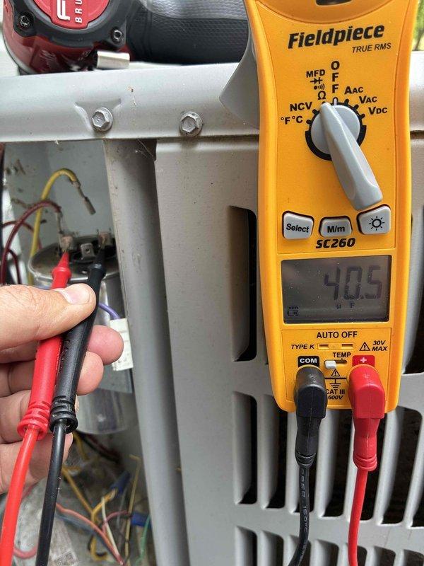 Completed MVP cooling maintenance visit on system of unknown age. Inspected evaporator coil and heat exchanger assembly, noting dust accumulation on metallic coiled tubes and fin surfaces. Performed electrical diagnostics using digital multimeter, measuring capacitance reading of 40.5 MFD at system terminals to verify proper component operation.