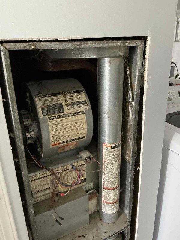 Conducted furnace replacement estimate for mobile home HVAC system. Assessed existing older furnace unit housed in wall-mounted utility compartment, documented equipment condition showing age-related wear, dust accumulation, and identified ceiling access panel requiring opening for complete system evaluation. Provided replacement recommendations based on current equipment configuration and mobile home installation requirements.
