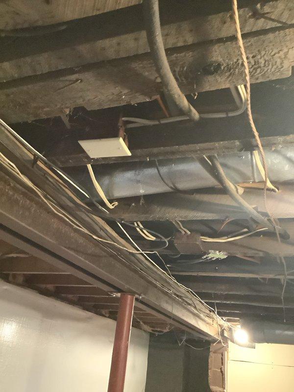 Performed follow-up pre-purchase electrical inspection on 73-year-old residence to verify grounding system integrity after initial home inspection could not confirm presence or quality of grounding at receptacles. Conducted comprehensive evaluation of electrical outlets throughout the property, tested grounding continuity at multiple receptacle locations, and inspected exposed wiring in basement ceiling area including electrical conduits running along floor joists. Documented findings with photographic evidence of electrical infrastructure and provided detailed assessment of grounding deficiencies for buyer's consideration prior to property closing.
