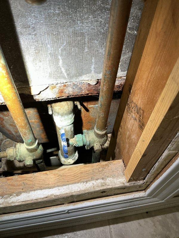 Responded to service call for bathtub drainage and shower leak issues. Upon inspection, identified faulty tub stopper assembly causing water leakage during bathing, water infiltration into electrical panel access behind shower wall during shower use, and malfunctioning overflow drain requiring sealing. Assessed bathtub drain mechanism with chrome cover and stopper, examined tile surround and spout installation, and inspected accessible plumbing infrastructure including copper supply lines and PVC drainage system showing age-related corrosion. Documented existing conditions of fixtures, drainage components, and compromised areas where water penetration was occurring near electrical panel access point.