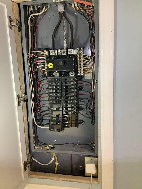 Responded to request for electrical outlet installation for oven application. Upon inspection of the 25-year-old residential electrical panel, assessed existing circuit capacity and breaker configuration to determine feasibility of installing two 20-amp dedicated circuits. Evaluated panel load distribution, verified available breaker spaces, and inspected existing wiring infrastructure in basement/utility area including routing paths through floor joists alongside existing plumbing and electrical systems. Documented current electrical panel condition showing organized circuit layout with main breaker assembly and individual branch circuits. Photographed installation area including exposed ceiling joists, existing utility runs, and access points for new circuit installation to support proper 240-volt oven connection requirements.