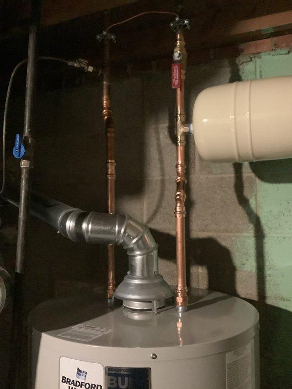 Replaced existing 40-gallon water heater with new Bradford White 40-gallon residential unit in basement utility area. Installation included new thermal expansion tank mounted to wall, new water shut-off valve, and complete copper piping connections with appropriate fittings and joints. Installed pressure relief valve and connected aluminum exhaust venting system. Unit comes with 10-year tank warranty and was tested for proper operation upon completion.