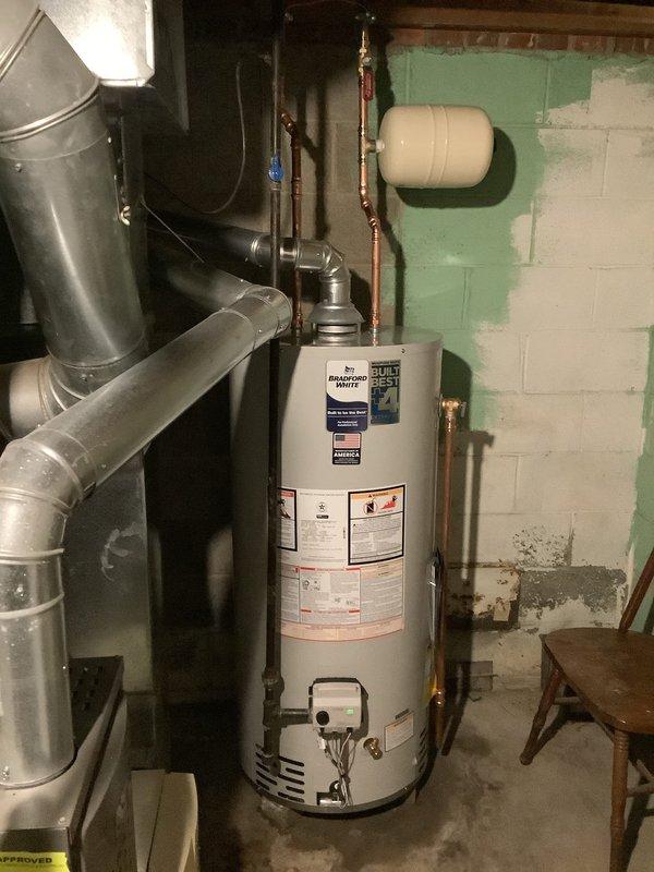 Replaced existing 40-gallon water heater with new Bradford White 40-gallon residential unit in basement utility area. Installation included new thermal expansion tank mounted to wall, new water shut-off valve, and complete copper piping connections with appropriate fittings and joints. Installed pressure relief valve and connected aluminum exhaust venting system. Unit comes with 10-year tank warranty and was tested for proper operation upon completion.