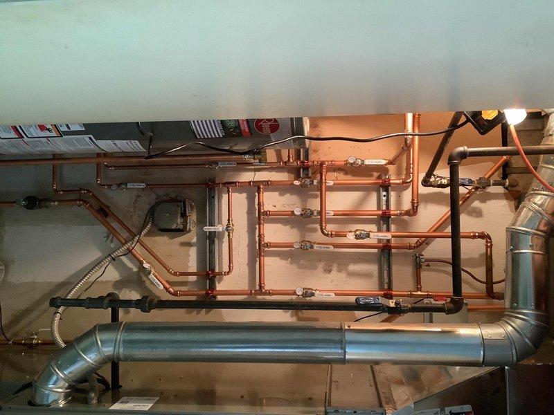 Completed comprehensive plumbing system upgrade involving multiple spigot replacements and mechanical room reconfiguration. Replaced hot and cold water spigots in garage with 4-6" frost-free units, installing plywood backing for proper mounting support. Replaced spigot serving mechanical room. Hard piped water heater installation with new ball valve for improved reliability and code compliance.

Rebuilt copper piping system in mechanical room, relocating and wall-mounting water meter for better accessibility and organization. Installed isolation valves on all hose bibs and outgoing water lines to provide individual shut-off capability for future maintenance. Capped leaking 1/2" copper line in loft area that previously ran to rear of home, eliminating inadequate freeze protection issue.

Work required coordination with water department for main water valve shut-off to facilitate safe completion of all plumbing modifications. All copper piping work completed using professional-grade mate