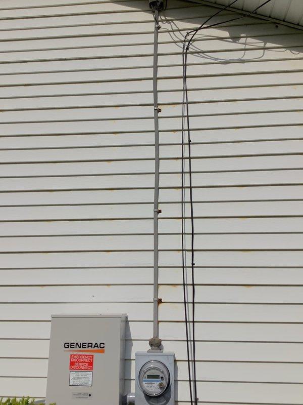 Responded to callback for persistent flickering lights following recent generator installation. Performed comprehensive inspection of Generac transfer switch, meter base connections, and associated conduit runs on exterior wall. Verified all electrical connections at transfer switch and service entrance for proper torque and continuity to eliminate loose connections as source of voltage fluctuations. Documented installation conditions with photographs for pre-inspection preparation, noting exterior conduit mounting and weatherproofing at penetration points.