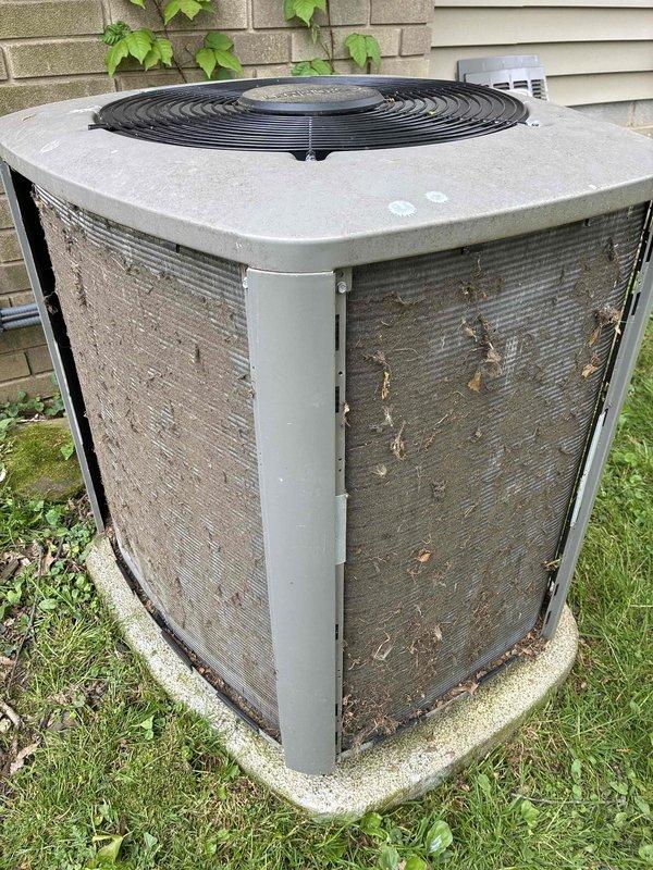 Completed cooling maintenance on outdoor air conditioning condenser unit. System was found operating properly with no mechanical issues identified. Unit exterior showed significant accumulation of dirt, dust, and debris on protective grilles and metal fins, with organic matter present on lower panels. Performed standard tune-up procedures and confirmed proper system operation upon completion.