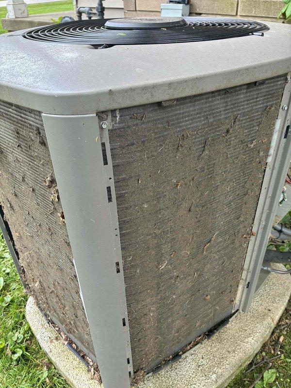 Completed cooling maintenance on outdoor air conditioning condenser unit. System was found operating properly with no mechanical issues identified. Unit exterior showed significant accumulation of dirt, dust, and debris on protective grilles and metal fins, with organic matter present on lower panels. Performed standard tune-up procedures and confirmed proper system operation upon completion.
