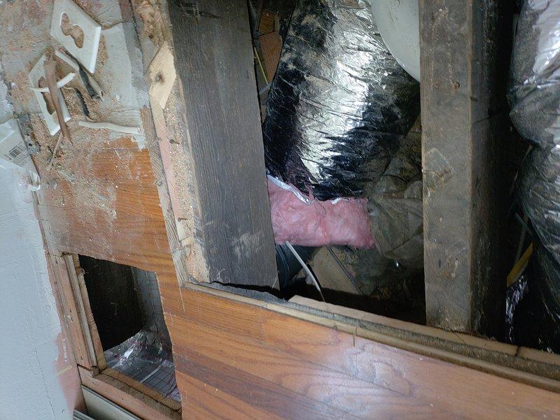 Completed reinstallation of tankless water heater venting system and furnace condensate drain line in attic space. Rerouted white PVC condensate piping from furnace unit to ensure proper drainage and code compliance, and reconfigured black flexible venting connections for the tankless system to achieve optimal exhaust flow and safety clearances.