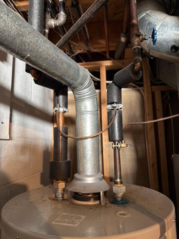 Responded to service call for natural gas water heater with burnt out burner assembly. Performed diagnostic inspection and documented existing GE brand tank-style water heater installation. Assessed burner condition and discussed repair versus replacement options with customer, including evaluation of unit age, efficiency, and long-term cost considerations. Photographed current installation showing plumbing connections, gas supply lines, temperature and pressure relief valve, and overall system configuration for customer reference and quote preparation.