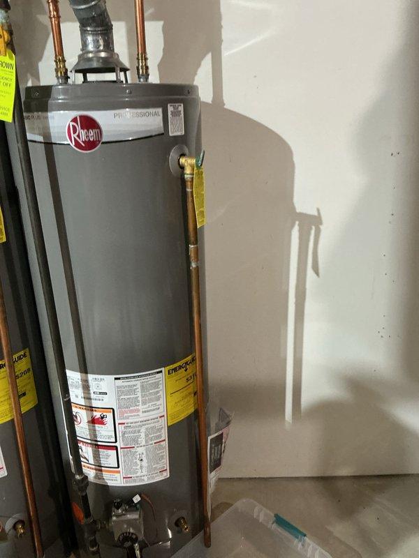 Responded to emergency call for leaking Rheem Professional tanked water heater experiencing significant discharge from temperature and pressure relief valve overflow. Upon arrival, immediately shut off gas supply to unit and drained tank completely to stop active leaking and prevent further water damage. Inspected 2024-installed water heater and T&P relief valve assembly for potential causes including excessive system pressure, thermal expansion issues, or faulty relief valve operation. Documented equipment condition and leak source with photographic evidence showing unit installation, piping configuration, and affected areas. System stabilized and made safe pending further diagnostic evaluation or component replacement as needed.