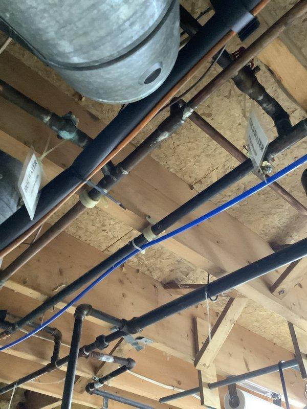 Responded to low water pressure complaint affecting entire home. Previous contractor had replaced pressure tank and installed new pressure switch without resolving the issue. Performed comprehensive assessment of plumbing system including pressure tank, pressure switch, and water distribution lines. Inspected water softener connections and piping throughout basement and crawl space areas. Identified corroded softener line as likely cause of pressure loss based on visual inspection of copper and black piping infrastructure. Documented existing plumbing configuration including water heater connections, supply lines, and pressure regulation components. Customer declined immediate repair authorization.