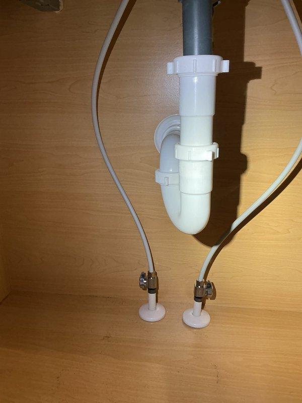 Responded to service call for low water pressure at bathroom sink. Upon inspection, observed water draining properly through P-trap assembly and drain system with no visible blockages or leaks in waste lines. Examined supply lines beneath vanity, which appeared to be flexible braided tubing in standard functional condition. Tested water flow at faucet and confirmed reduced pressure issue. Likely cause determined to be restricted flow at faucet aerator or supply valve partially closed. Documented existing plumbing configuration with photos showing under-sink connections and drain assembly for service records.