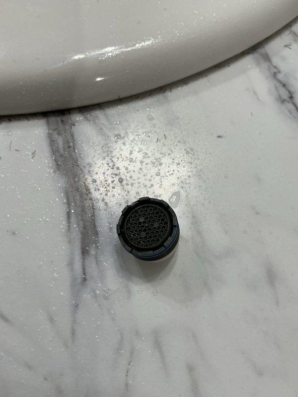 Responded to service call for low water pressure at bathroom sink. Upon inspection, observed water draining properly through P-trap assembly and drain system with no visible blockages or leaks in waste lines. Examined supply lines beneath vanity, which appeared to be flexible braided tubing in standard functional condition. Tested water flow at faucet and confirmed reduced pressure issue. Likely cause determined to be restricted flow at faucet aerator or supply valve partially closed. Documented existing plumbing configuration with photos showing under-sink connections and drain assembly for service records.