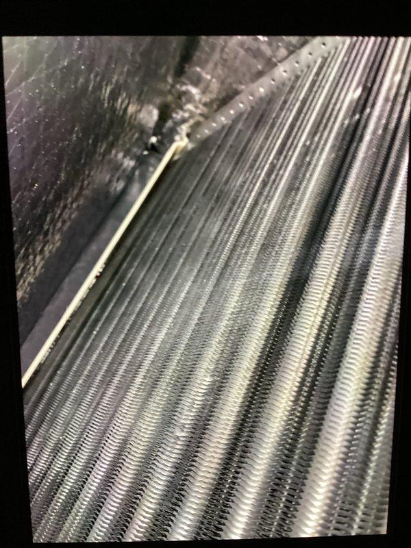 Completed MVP recurring cooling maintenance visit on 2-year-old system. Performed standard system inspection and diagnostics, recording temperature readings of 52.9°F at evaporator coil using infrared thermometer. Documented moderate dust and debris accumulation on condenser coil fins requiring attention at next service interval.