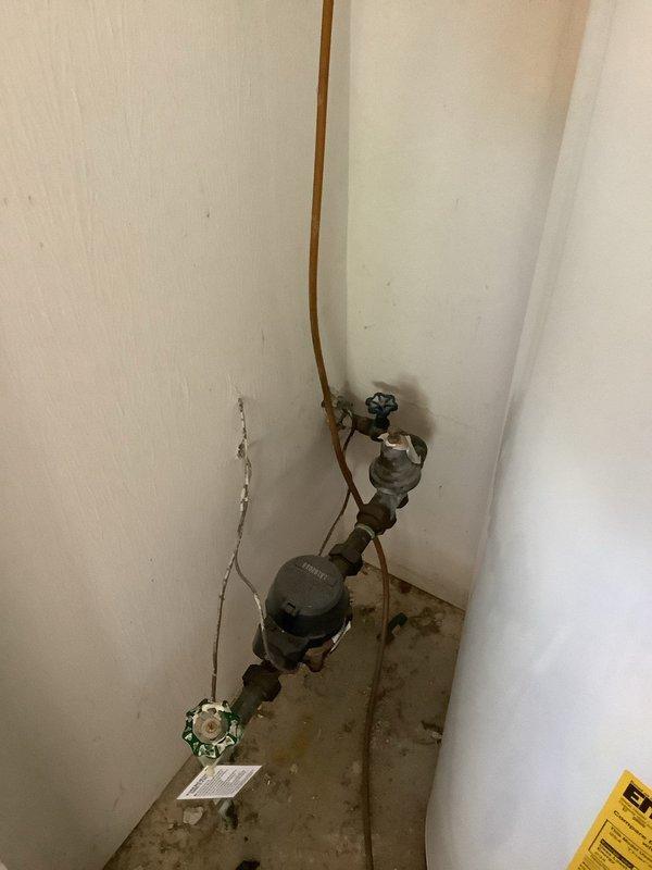 Installed automatic shut-off valve on main water supply line in 30-year-old residential property. Work included integration with existing water meter assembly and copper piping infrastructure, installation of brass shut-off valves with cross-handle controls on main line, and installation of under-sink automatic shut-off valve with flexible supply connections. All installations tested and verified operational with no leaks detected.