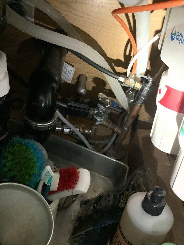 Installed automatic shut-off valve on main water supply line in 30-year-old residential property. Work included integration with existing water meter assembly and copper piping infrastructure, installation of brass shut-off valves with cross-handle controls on main line, and installation of under-sink automatic shut-off valve with flexible supply connections. All installations tested and verified operational with no leaks detected.