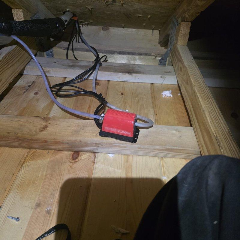 Responded to water leak complaint on recently installed mini-split system with water dripping through ceiling. Accessed attic space and inspected condensate drain line installation on mini-split air handler. Found improper drain line pitch causing water to back up and overflow from drain pan, resulting in ceiling leak below unit.