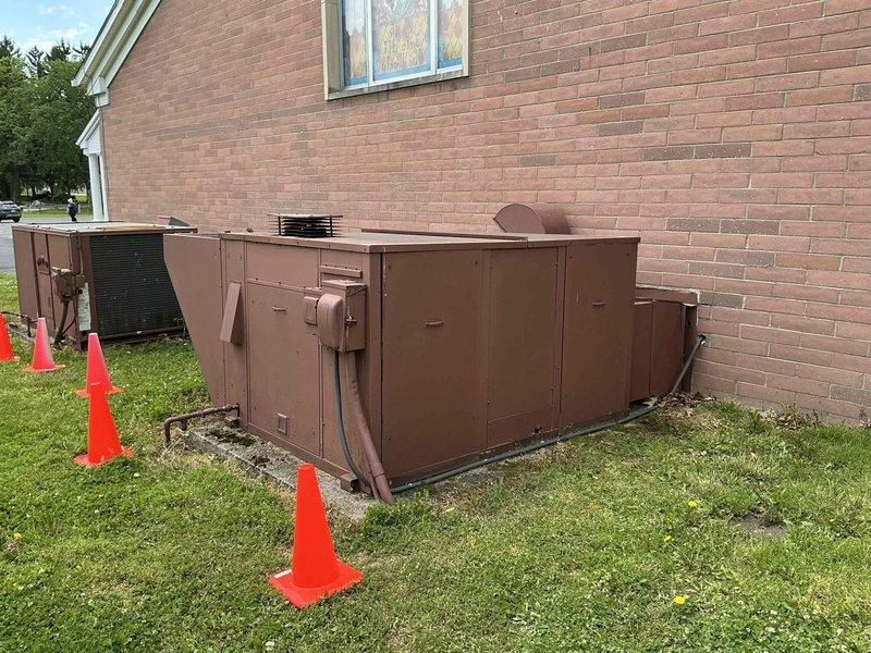 Conducted commercial air conditioning replacement estimate for church facility. Evaluated existing large-capacity brown HVAC unit positioned on concrete pad adjacent to building, assessed aging electrical disconnect and power supply components showing significant corrosion and weathering, and documented equipment specifications and site conditions to provide comprehensive replacement recommendations.