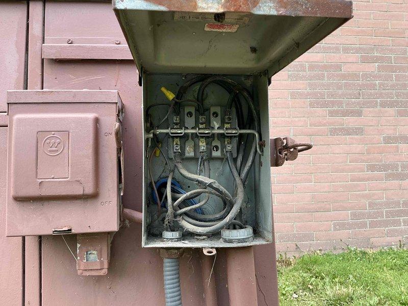 Conducted commercial air conditioning replacement estimate for church facility. Evaluated existing large-capacity brown HVAC unit positioned on concrete pad adjacent to building, assessed aging electrical disconnect and power supply components showing significant corrosion and weathering, and documented equipment specifications and site conditions to provide comprehensive replacement recommendations.
