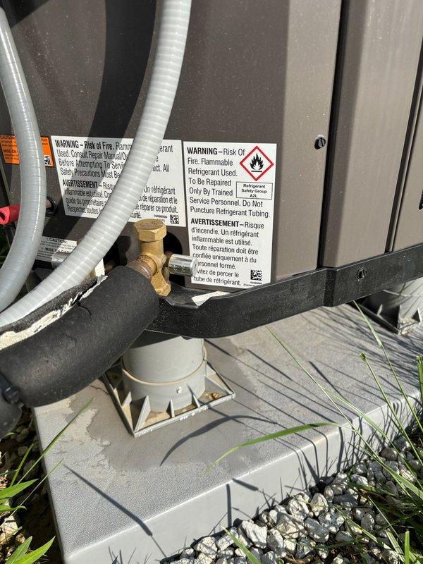 Responded to emergency water leak call for newly installed furnace system causing active water damage to interior flooring. Upon arrival, identified condensate drainage issue originating from HVAC unit exterior components. Inspected refrigerant lines, drain pan, and condensate removal system. Located source of leak at condensate collection point where improper drainage was allowing water to overflow and migrate into living space through floor penetration. Corrected drainage configuration, verified proper condensate flow, and confirmed leak was stopped. Documented floor damage in corner area where laminate flooring had been affected by water intrusion. System tested and operating properly with no further leakage detected at time of departure.