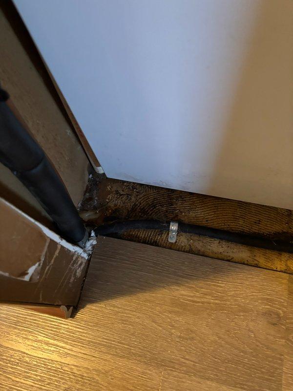 Responded to emergency water leak call for newly installed furnace system causing active water damage to interior flooring. Upon arrival, identified condensate drainage issue originating from HVAC unit exterior components. Inspected refrigerant lines, drain pan, and condensate removal system. Located source of leak at condensate collection point where improper drainage was allowing water to overflow and migrate into living space through floor penetration. Corrected drainage configuration, verified proper condensate flow, and confirmed leak was stopped. Documented floor damage in corner area where laminate flooring had been affected by water intrusion. System tested and operating properly with no further leakage detected at time of departure.