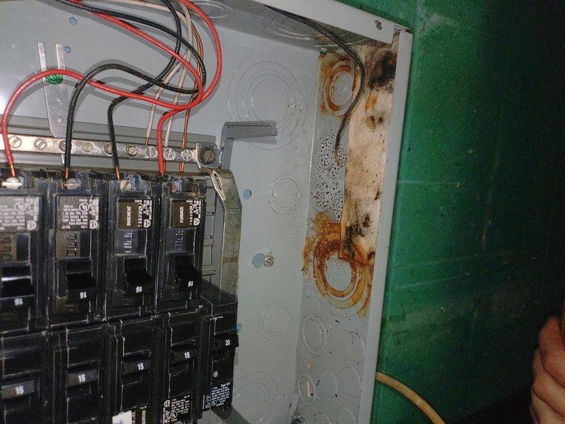 Responded to intermittent partial power outages affecting approximately half the circuits in the residence. Upon inspection, discovered extensive water damage, rust, and corrosion throughout the main electrical panel enclosure, with heavy oxidation on interior surfaces and bus bars. The moisture intrusion had compromised panel integrity and created unsafe conditions causing the random power interruptions. Documented panel deterioration with photographs showing rust staining, peeling paint, corrosion around knockout holes, and possible mold growth. Recommended immediate panel replacement due to safety hazards and explained that the existing panel was beyond repair and posed fire and electrocution risks.