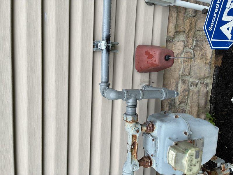 # Electrical Service - Generator Gas Line Maintenance

Responded to follow-up service call for previously installed generator system where the black pipe gas line had not been painted during initial installation. Upon arrival, confirmed visible rust formation on exposed metal gas piping and fittings mounted on exterior wall. Prepared and painted all unpainted black pipe gas line components using appropriate rust-inhibiting paint suitable for gas line applications. Ensured proper coverage of all pipe sections, T-joints, elbow fittings, and connection points to prevent further oxidation and corrosion. Verified electrical connections to generator remained secure and operational per manufacturer specifications. All work completed in accordance with local codes and safety standards for exterior gas line installations.