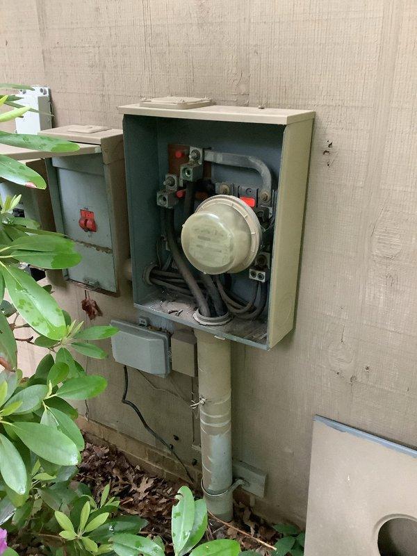 Performed electrical panel inspection and assessment. Documented existing electrical service installation including exterior meter box with visible internal components and weathered disconnect box, as well as interior main breaker panel with multiple circuit breakers and wire routing. Customer requested quote for new breaker box replacement due to condition of existing equipment. Captured photographic documentation of current panel configuration and exterior utility connections for estimate preparation.