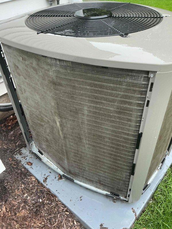 Completed routine MVP cooling maintenance visit on residential air conditioning system. Upon inspection, found outdoor condenser unit with significant dirt and debris accumulation on heat exchanger coil fins and filter surfaces, which can restrict airflow and reduce system efficiency. Unit exterior showed normal weathering consistent with outdoor exposure, with mulch and organic debris present around base. Condenser fan grille and motor housing appeared operational, and unit was properly positioned on concrete pad with adequate clearance from building structure.