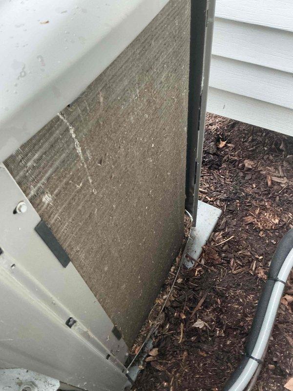 Completed routine MVP cooling maintenance visit on residential air conditioning system. Upon inspection, found outdoor condenser unit with significant dirt and debris accumulation on heat exchanger coil fins and filter surfaces, which can restrict airflow and reduce system efficiency. Unit exterior showed normal weathering consistent with outdoor exposure, with mulch and organic debris present around base. Condenser fan grille and motor housing appeared operational, and unit was properly positioned on concrete pad with adequate clearance from building structure.