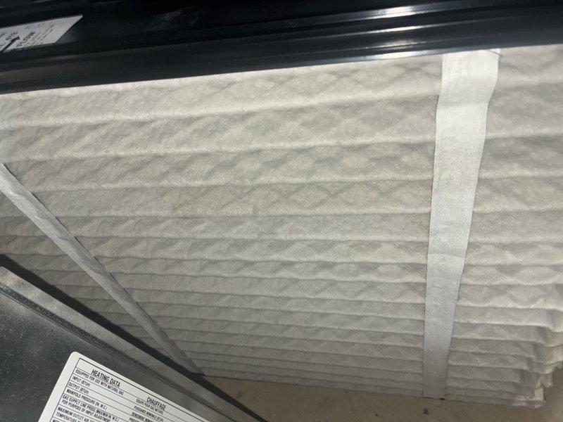 Completed MVP recurring maintenance visit on 2-year-old cooling system. Inspected and photographed air filter showing clean condition with proper pleating and secure installation within unit housing. Examined evaporator coil assembly, confirming aluminum fins and copper refrigerant tubing in good operational condition with only minor dust accumulation consistent with normal use.
