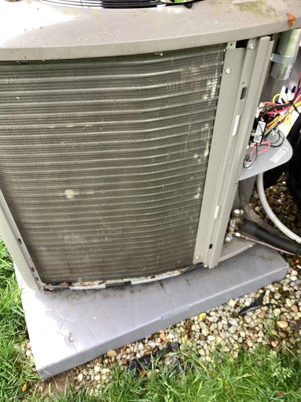 Completed MVP cooling maintenance visit on 2-year-old HVAC system. Performed comprehensive inspection of indoor furnace unit, verifying proper operation of gas valve assembly, ignition components, and electrical connections. Inspected outdoor condensing unit and observed dirt and debris accumulation on condenser coils. Assessed condenser coil condition with front panel removed, noting horizontal fins require cleaning to maintain optimal heat transfer efficiency. Verified electrical connections and wiring harness at outdoor unit, confirming all wire terminations secure. Documented system condition through photographs showing internal furnace components, PVC venting connections with rubber boots, and outdoor unit positioned on concrete pad with gravel base. System operational at time of service completion.