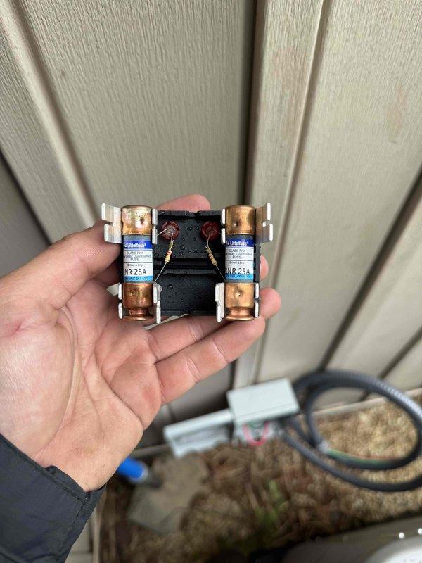 Completed full HVAC system installation including outdoor condensing unit and associated electrical components. Installed 25-amp Littelfuse fuses in dual fuse assembly mounted to exterior wall for proper electrical protection and disconnect functionality. Set outdoor unit on gravel pad with proper leveling and positioning. Connected copper refrigerant line sets with insulated suction lines, secured all brass service valves and fittings, and ensured proper refrigerant line routing from outdoor unit. All electrical connections completed per manufacturer specifications and local code requirements. System tested and verified operational.