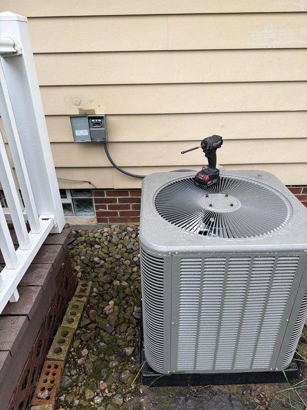 # HVAC Install - A/C & Coil

Successfully completed installation of new air conditioning system including outdoor condensing unit and indoor evaporator coil. Installed gray cylindrical condenser unit on exterior concrete pad with proper clearances from structure. Mounted electrical disconnect box on siding with conduit run to unit. Inside mechanical room, integrated new evaporator coil with existing furnace/air handler system. Connected refrigerant lines between indoor and outdoor components using copper tubing with proper insulation. Installed condensate drainage system utilizing white PVC piping routed appropriately from coil. Verified all electrical connections meet code requirements. System tested for proper operation including refrigerant pressures, airflow, and temperature differential. Unit cycling correctly with all safety controls functioning as designed.