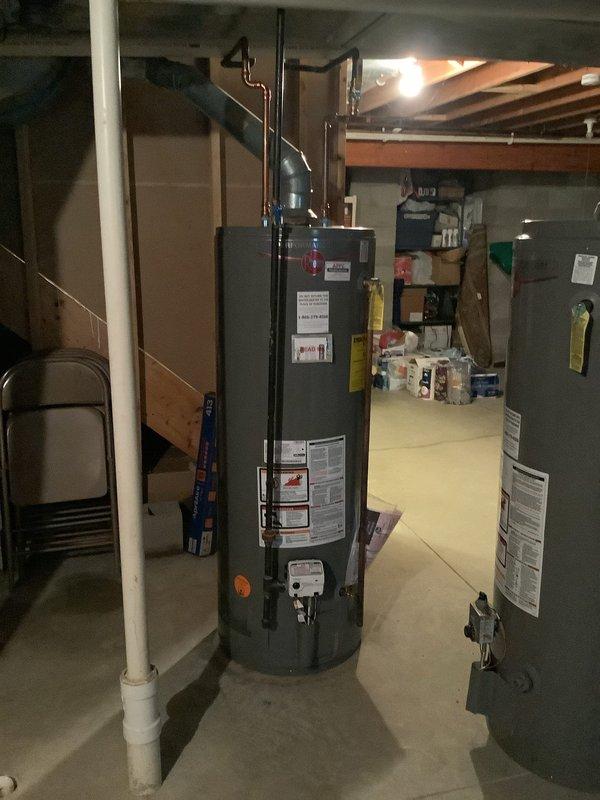 Responded to water leak service call for hot water tank pooling water in basement. Upon arrival, inspected the natural gas water heater and surrounding area, identifying the source of water accumulation on the concrete floor. Assessed the unit's condition, checked all plumbing connections, and documented the installation with photographs showing the cylindrical water heater, copper supply lines, and basement utility configuration. Service completed during standard business hours with MVP membership applied.