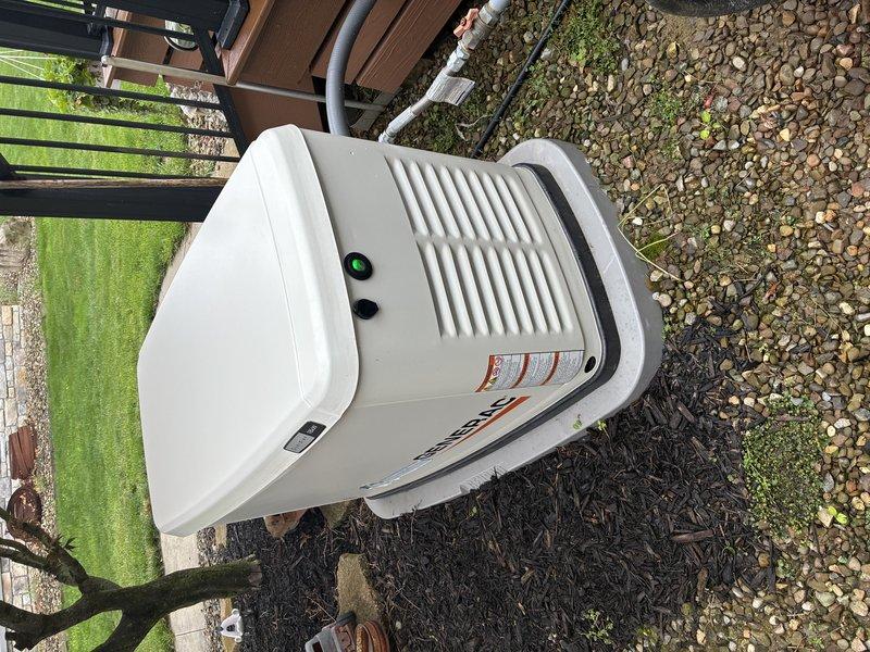 Performed maintenance inspection on residential Generac standby generator following customer report of indicator light remaining illuminated and unit shutting down prematurely during recent power outage. Conducted visual inspection of exterior-mounted unit, verified proper installation on mulch bed with adequate clearance and ventilation. Assessed generator control panel status lights and reviewed recent operational history. Inspected fuel supply lines, electrical connections, and exhaust system for proper function. Documented unit condition with photographs showing one-year-old generator in good physical condition with all manufacturer labels intact. Explained normal operational indicator light behavior to customer and verified automatic transfer switch functionality. Unit tested successfully with no immediate faults detected during service call.