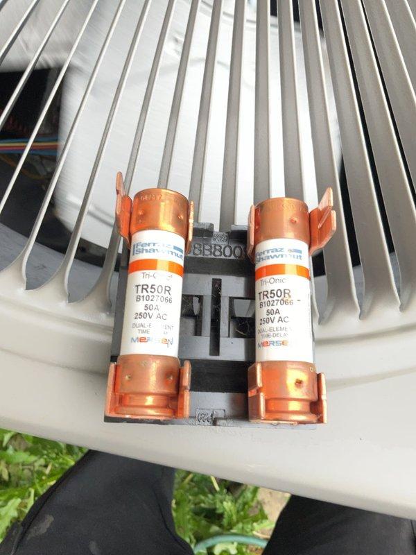 Completed routine preventative maintenance on 3-year-old air conditioning system. Inspected electrical disconnect and fuses, confirming TR50R 50A/250V fuses in good condition with no signs of damage or deterioration. Verified all electrical connections secure and properly aligned within housing. Tested system operation and measured performance parameters to ensure unit operating within manufacturer specifications.