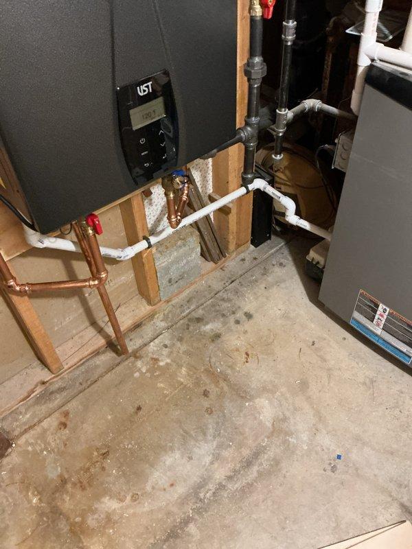 Installed customer-supplied tankless water heater in basement utility area with proper venting through exterior wall. Configured gas supply lines, water connections with copper and PVC piping, and integrated digital control panel for temperature regulation. Coordinated parts staging and completed installation with Nav/Rin Kit components as specified.