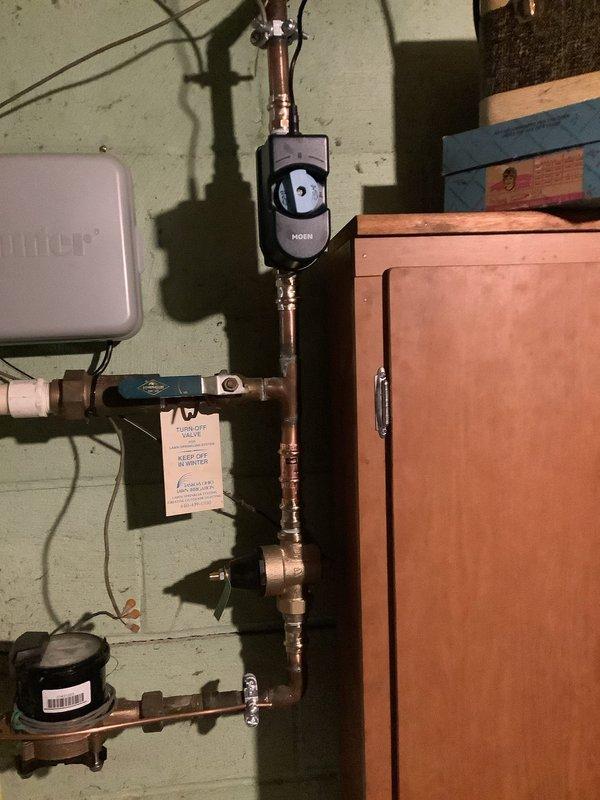 Completed installation of Moen Flo smart water monitoring system with integrated pressure reducing valve and thermal expansion tank on main water line. System was professionally mounted and secured with proper copper piping connections, electrical wiring completed, and device activated with green indicator lights confirming operational status.