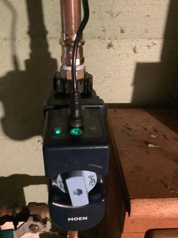 Completed installation of Moen Flo smart water monitoring system with integrated pressure reducing valve and thermal expansion tank on main water line. System was professionally mounted and secured with proper copper piping connections, electrical wiring completed, and device activated with green indicator lights confirming operational status.