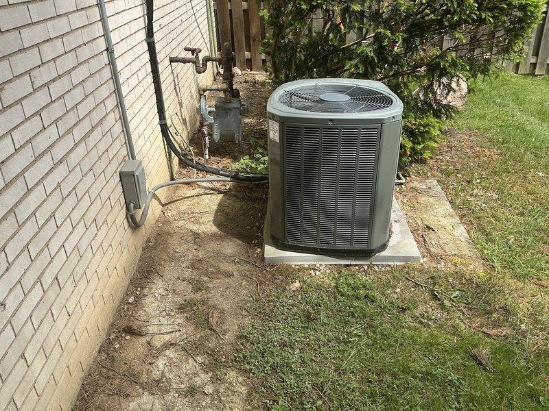 Completed estimate for air conditioning system replacement following exterior damage to existing 2014 condenser unit caused by lawn mower impact. Assessed damaged Trane condenser unit positioned on concrete pad against residential brick exterior, evaluated electrical disconnect and associated conduit connections, and documented current installation configuration including gas meter proximity and utility routing. Provided comprehensive replacement quote for new system installation to restore cooling capacity.