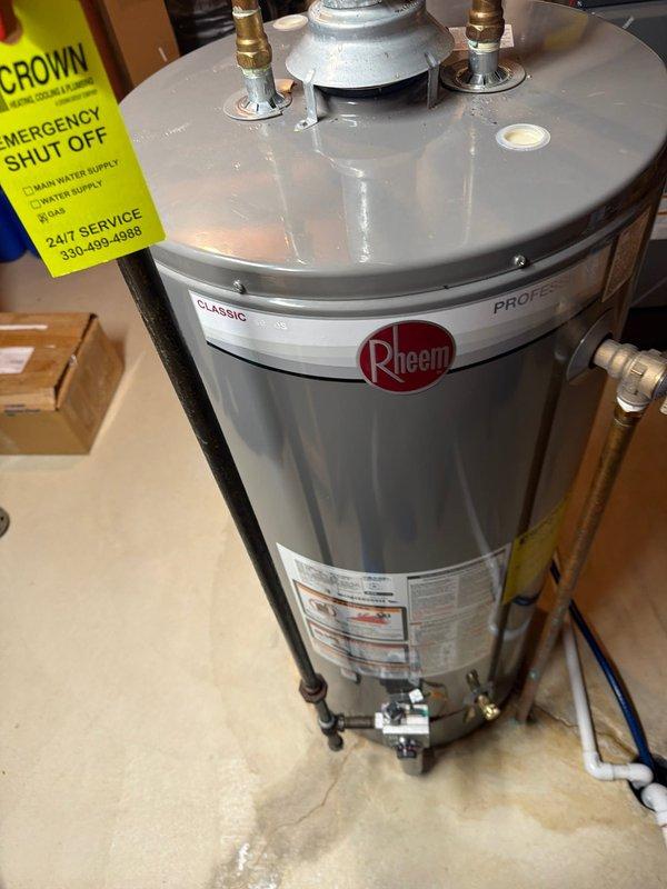 Provided estimate for replacement of a 2017 manufactured 40-gallon gas water heater exhibiting active leakage. Assessed existing Rheem Classic Professional series unit installed in basement utility area with standard top-mount brass connections for hot and cold water supply lines, temperature and pressure relief valve, and gas control assembly. Documented current installation configuration including copper supply piping, PVC venting system, expansion tank mounting, and floor positioning to ensure accurate replacement specifications and code compliance for new equipment installation.