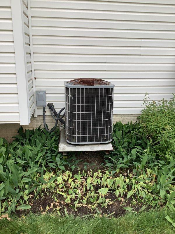 Completed full HVAC system installation including 80% efficiency furnace, 2-ton air conditioning condenser unit with matching evaporator coil, and AirScrubber air purification system. Outdoor condenser positioned on concrete pad against building exterior with proper electrical disconnect and line set connections, indoor furnace installed in basement utility area with supply and return ductwork integration, and AirScrubber mounted to provide whole-home air treatment. All equipment operational and tested for proper performance upon completion.