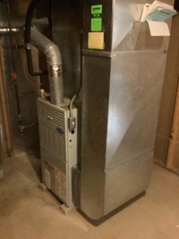 Completed full HVAC system installation including 80% efficiency furnace, 2-ton air conditioning condenser unit with matching evaporator coil, and AirScrubber air purification system. Outdoor condenser positioned on concrete pad against building exterior with proper electrical disconnect and line set connections, indoor furnace installed in basement utility area with supply and return ductwork integration, and AirScrubber mounted to provide whole-home air treatment. All equipment operational and tested for proper performance upon completion.
