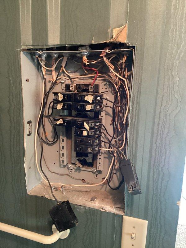 Responded to reported crackling sounds from electrical panel occurring when high-draw appliances (microwave and washer) were in operation. Performed diagnostic inspection of main electrical panel and associated components. Upon examination, found disorganized wiring with multiple conductors bundled together throughout the panel enclosure, along with evidence of age-related wear and deterioration. Inspected all circuit breaker connections, bus bar contact points, and wire terminations for signs of arcing, overheating, or loose connections that could cause audible crackling. Verified proper torque on all breaker connections and main lugs. Evaluated panel capacity and load distribution across circuits to ensure adequate amperage for simultaneous operation of high-current appliances. Documented panel condition with photographs showing internal wiring configuration, breaker arrangement, and overall installation state for record-keeping purposes.