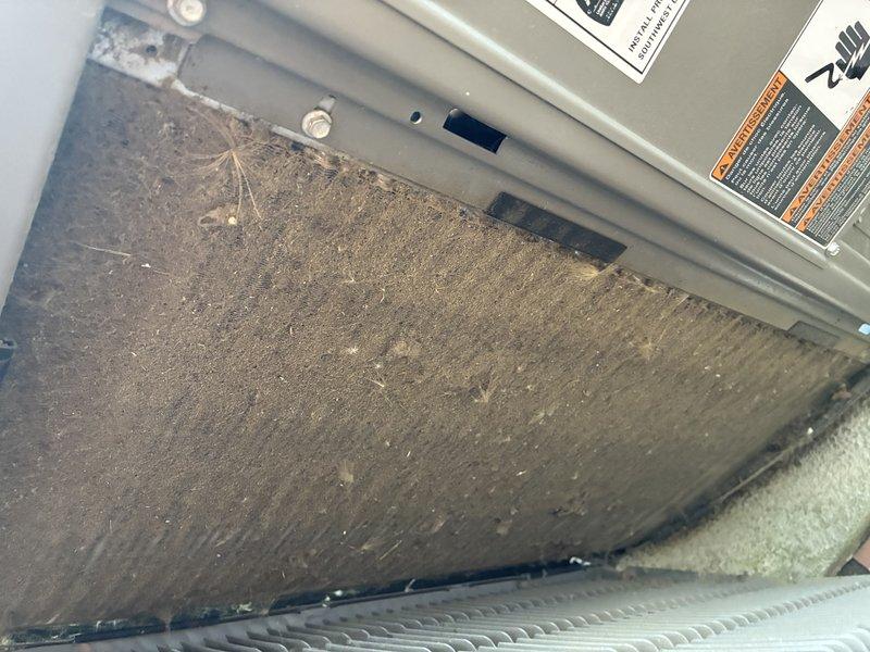 Completed MVP cooling maintenance visit for recurring service customer. Upon inspection, discovered heavily clogged air filter with significant dust and debris accumulation requiring immediate attention. Documented existing conditions with photographs showing thick gray-brown buildup across entire filter surface, indicating extended service interval. Removed and replaced dirty air filter to restore proper airflow and system efficiency. Verified HVAC unit operation and ensured all access panels were properly secured with manufacturer labels intact. System returned to optimal operating condition with improved air quality and circulation.