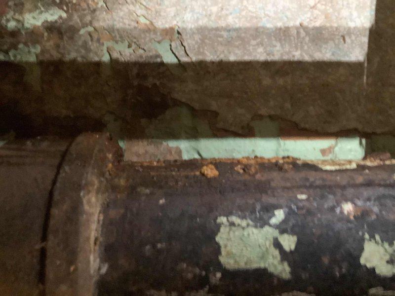 Responded to water leak on main drain line in 100-year-old residential property. Upon inspection, located active leak on approximately 50-year-old main drain pipe in crawlspace area. Documented deteriorated pipe condition showing significant wear, peeling coating, and corrosion on cast iron drain line. Photographed affected area including compromised pipe sections and surrounding infrastructure displaying moisture damage and age-related deterioration. Advised customer that while other plumbing has been replaced throughout the home, this original main drain section requires replacement due to advanced age and failing integrity. Provided service window availability for scheduling necessary repairs.