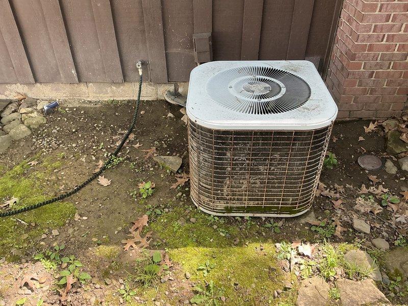 Completed estimate for replacement of 37-year-old residential HVAC system. Assessed outdoor condenser unit showing significant age-related deterioration, including weathered housing, stained panels, and moss growth on concrete pad. Evaluated indoor furnace and ductwork system in basement mechanical room. Provided comprehensive replacement quote accounting for complete system changeout including outdoor condensing unit and indoor air handler with associated ductwork modifications as needed. Advised homeowner of pet hair considerations during installation process.