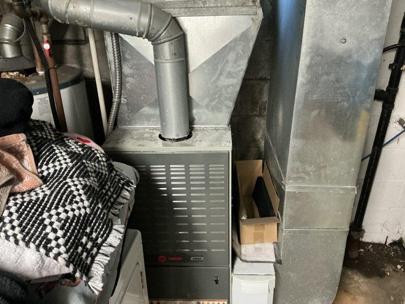 Completed estimate for replacement of 37-year-old residential HVAC system. Assessed outdoor condenser unit showing significant age-related deterioration, including weathered housing, stained panels, and moss growth on concrete pad. Evaluated indoor furnace and ductwork system in basement mechanical room. Provided comprehensive replacement quote accounting for complete system changeout including outdoor condensing unit and indoor air handler with associated ductwork modifications as needed. Advised homeowner of pet hair considerations during installation process.